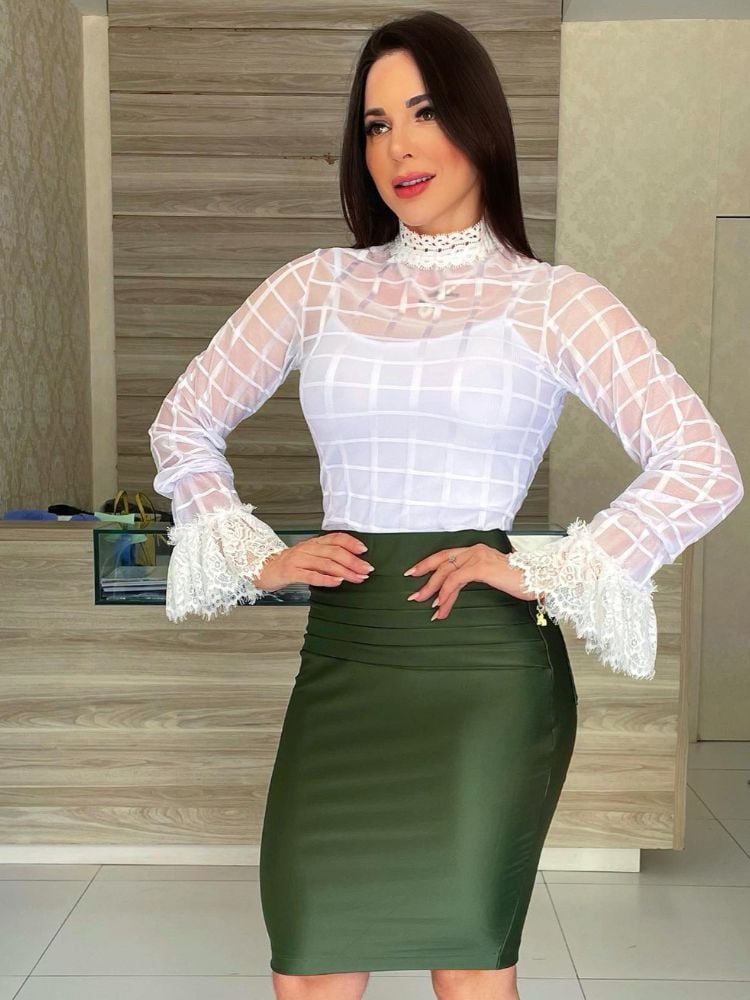 Mulher de pele clara usando camisete branca por baixo de body de tule branco e saia midi verde