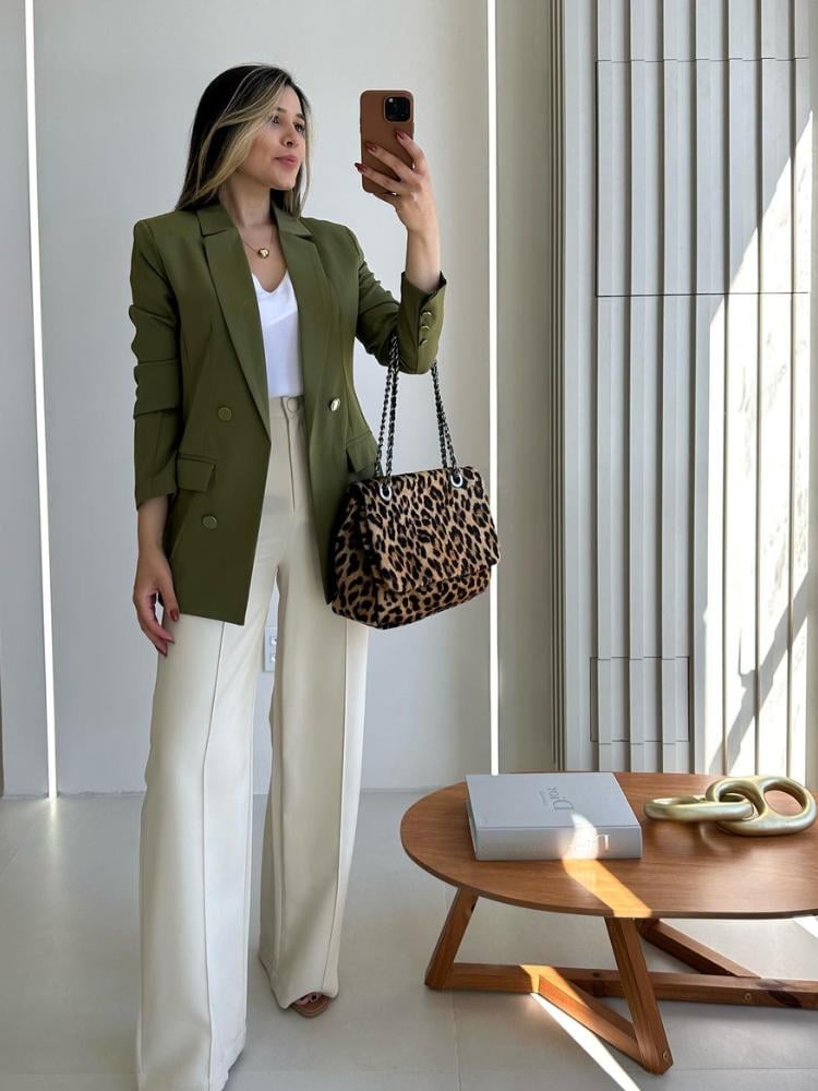 Mulher de pele clara usando regata de seda branca, blazer verde musgo e calça social bege 