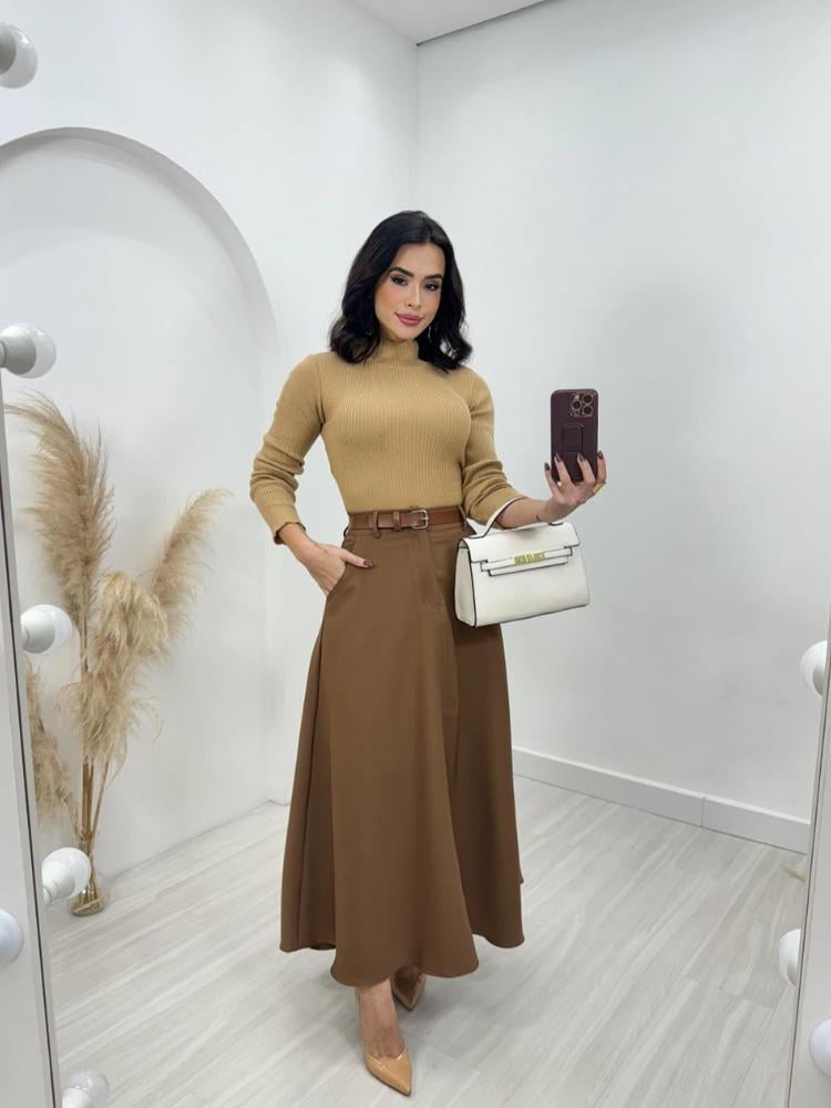 Mulher de pele clara usando blusa bege, saia midi marrom e salto 