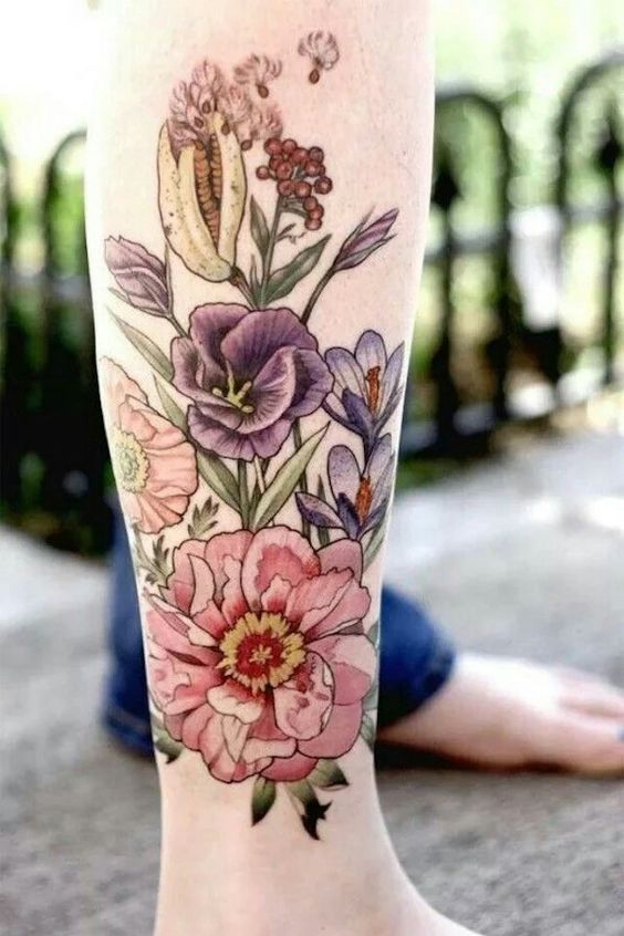 Foto de tatuagem de buquê de flores coloridas no braço