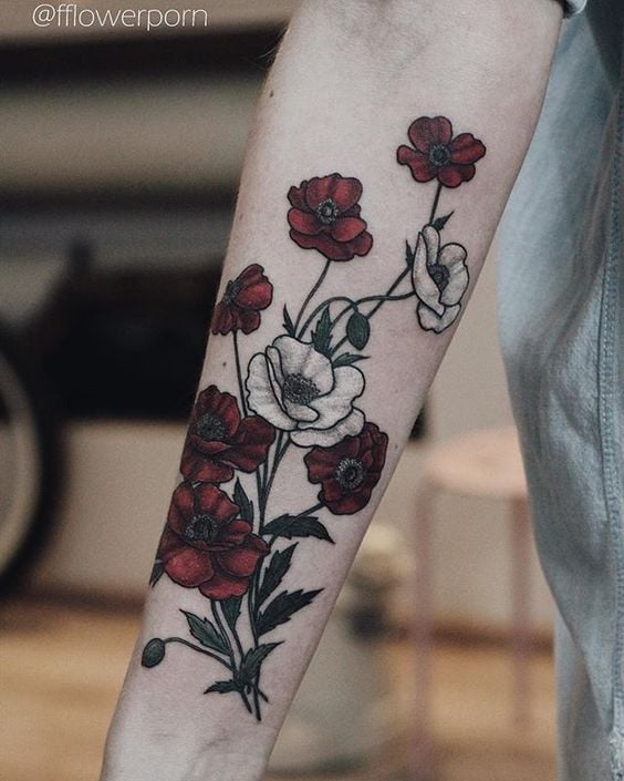 Foto de tatuagem de ramo de flores vermelhas e brancas no braço