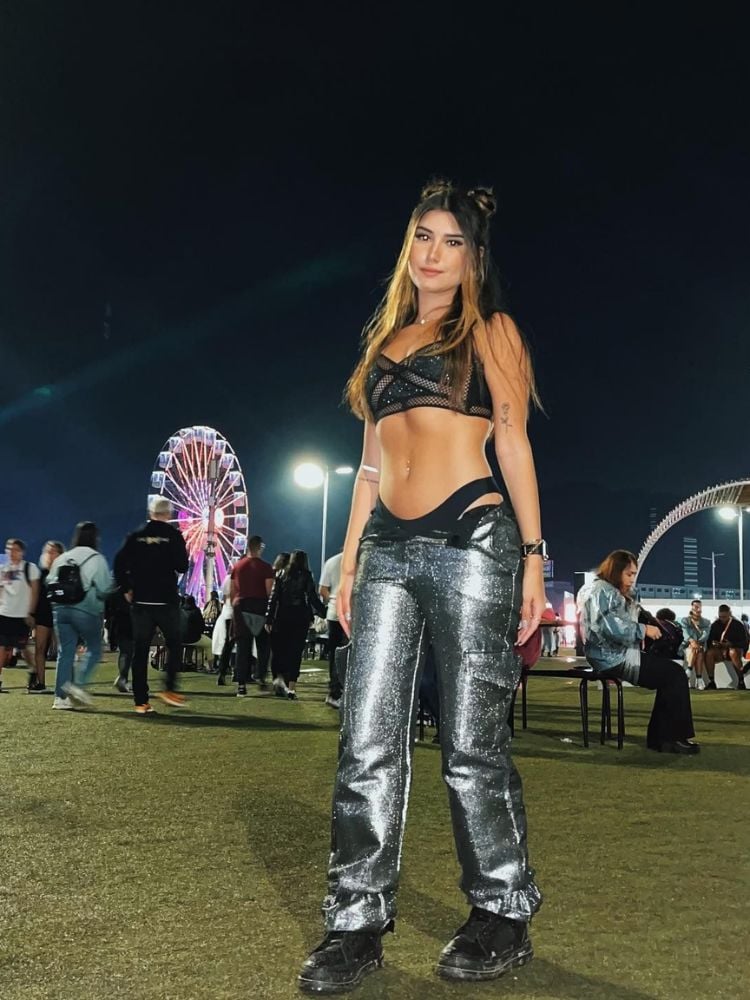 Mulher de pele clara no Rock in Rio usando top preto com glitter e calça metalizada 