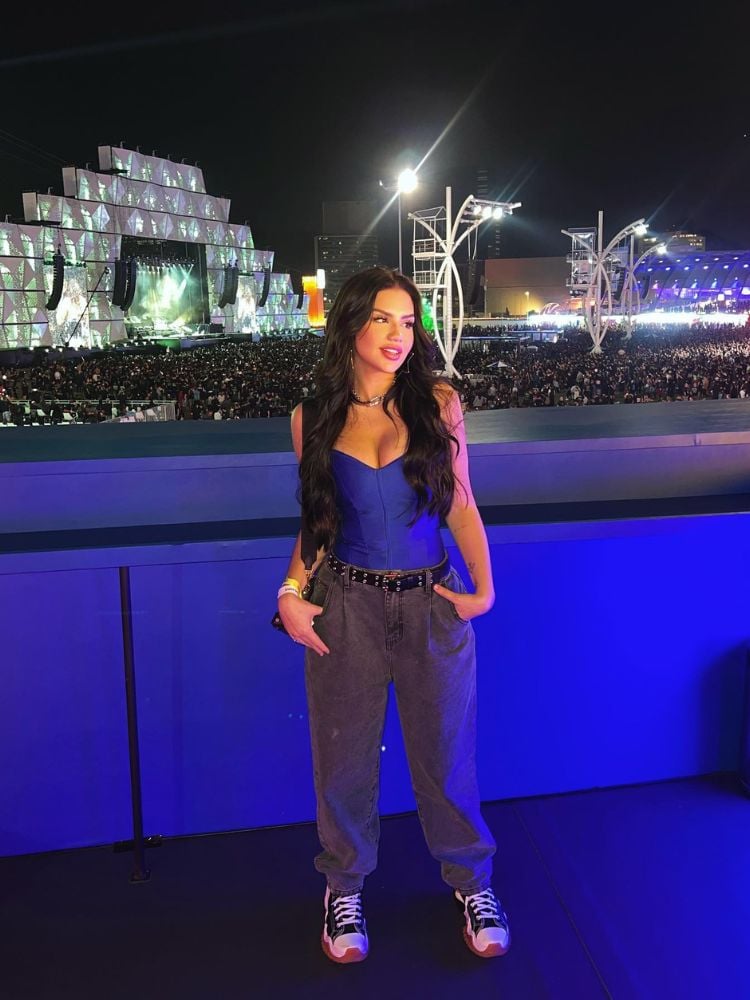 Vivi usando corset azul, calça preta e tênis