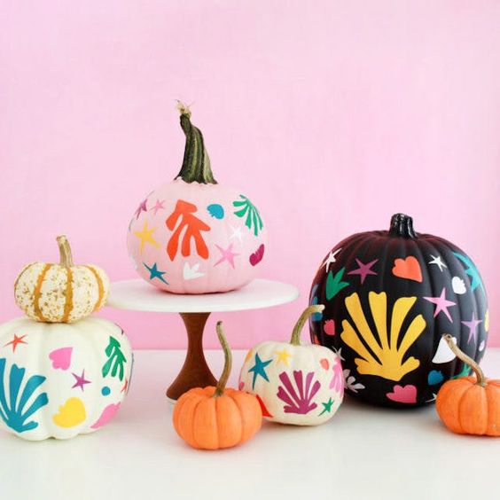 Foto de abóboras decoradas com tintas coloridas para o Halloween.