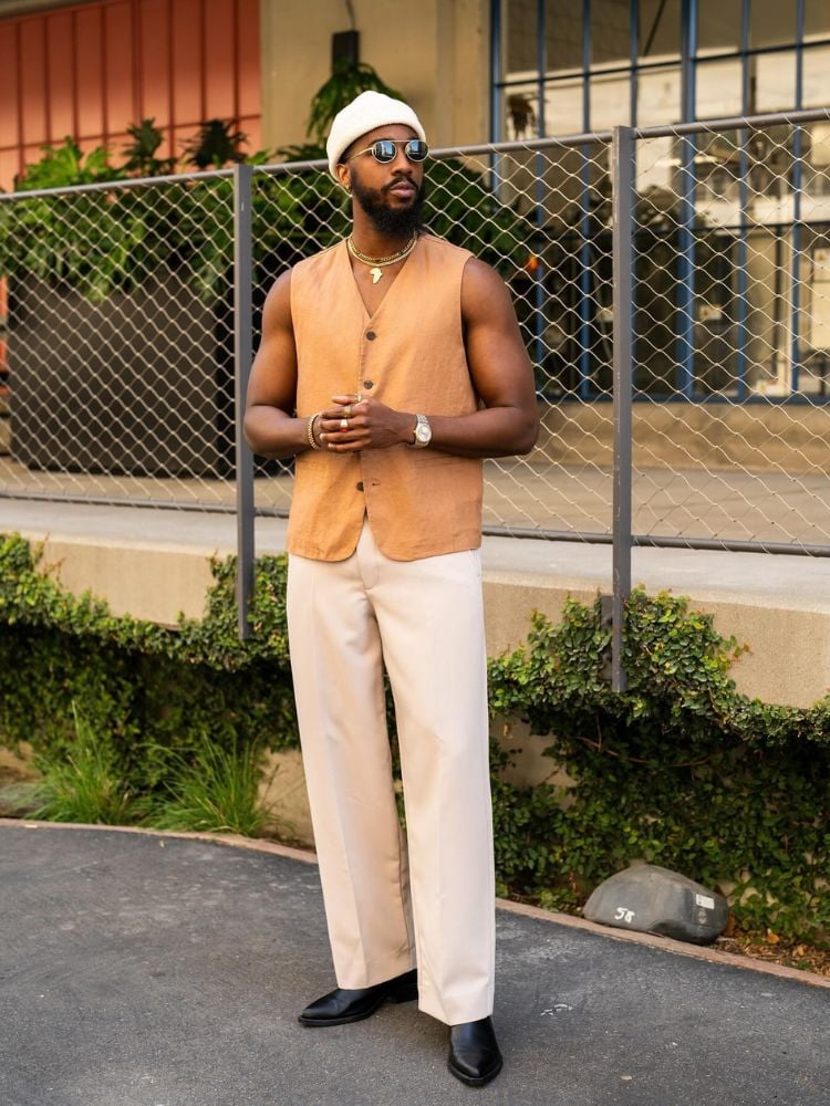 Foto de homem com silhueta trapézio usando colete cáqui e calça off white