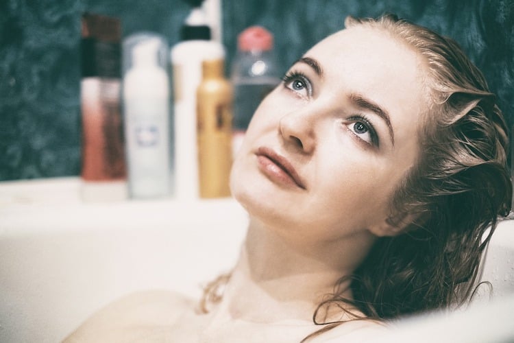 mulher jovem tomando banho de banheira