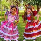 Duas gartoinhas usando vestido de chita para festa junina em gramado