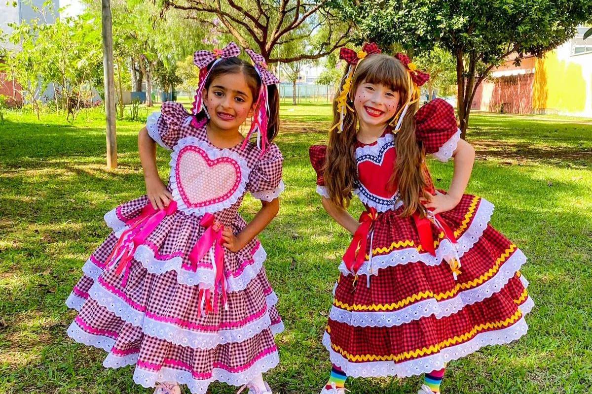 Duas gartoinhas usando vestido de chita para festa junina em gramado