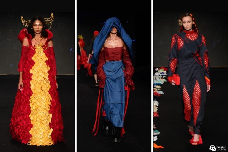 Três modelos desfilam na passarela do DFB Festival 2024. O primeiro veste um longo vermelho com detalhes amarelos, o segundo usa um conjunto azul com capuz, e o terceiro tem uma roupa preta com detalhes vermelhos.