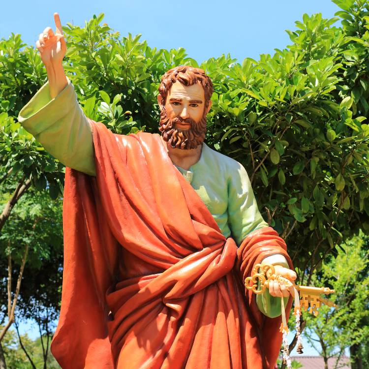 Foto de estátua de São Pedro, com vestimentas laranjas e verde e segurando chave