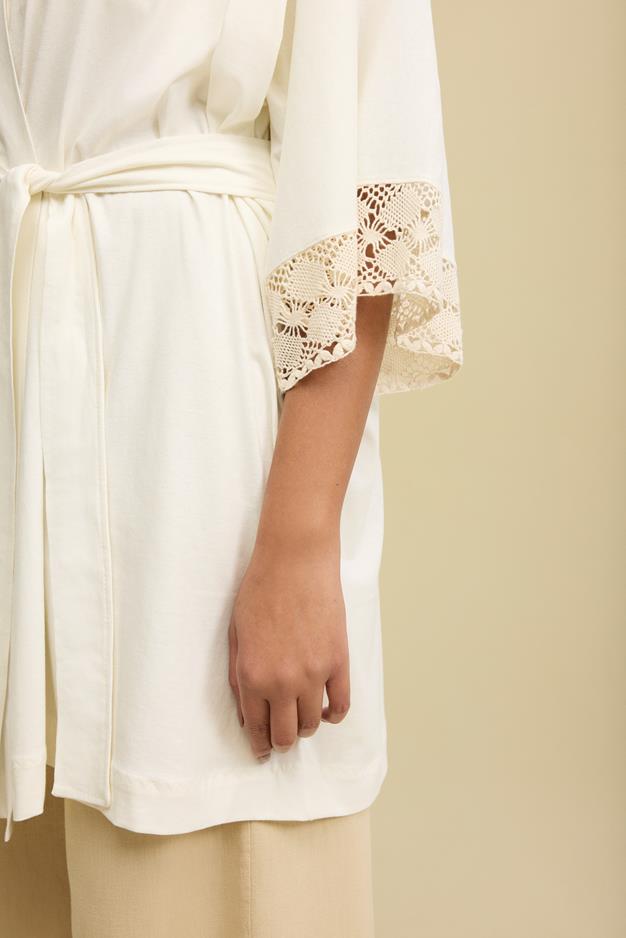 foto de detalhe de manga de blusa branca rendada