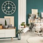 Foto de apartamento pequeno decorado com paredes verdes, quarto integrado com sala, diversos itens decorativos coloridos e móveis claros