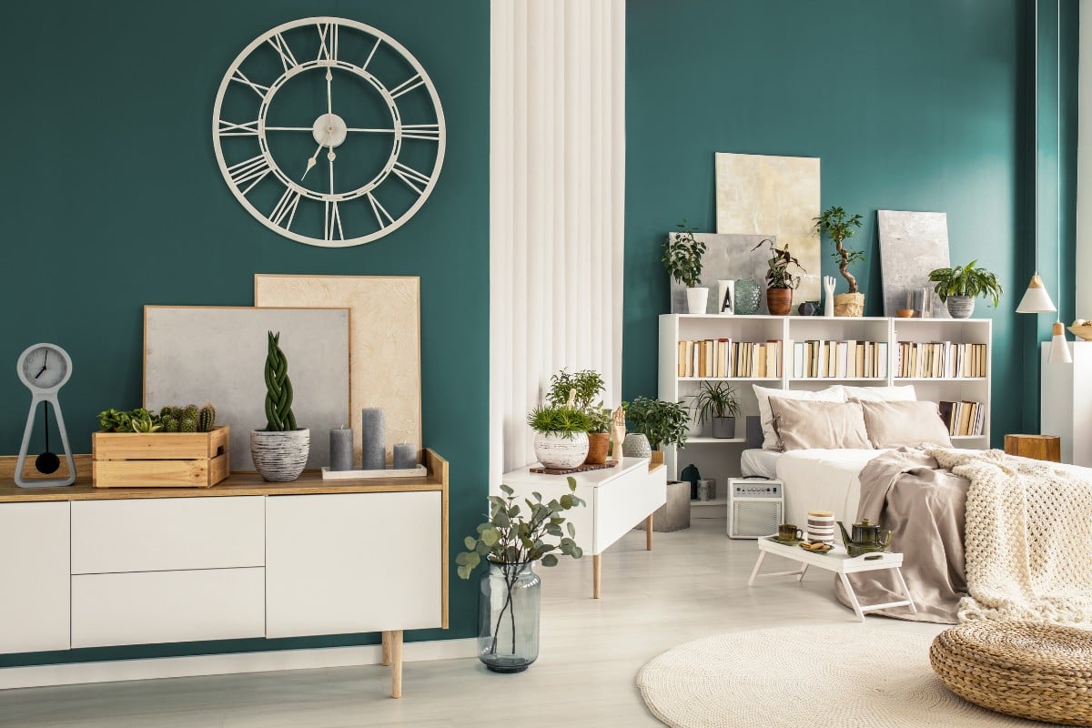 Foto de apartamento pequeno decorado com paredes verdes, quarto integrado com sala, diversos itens decorativos coloridos e móveis claros