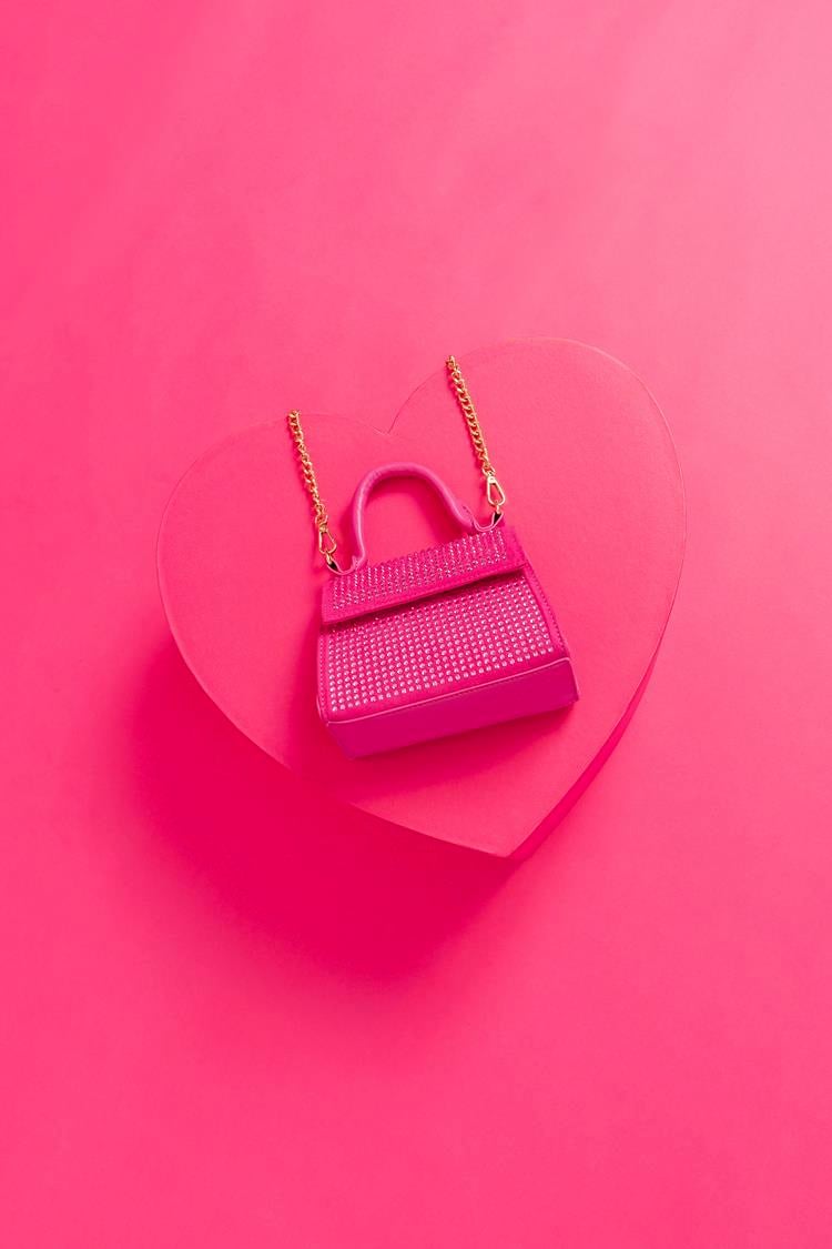 foto de bolsa rosa pequena de alça dourada