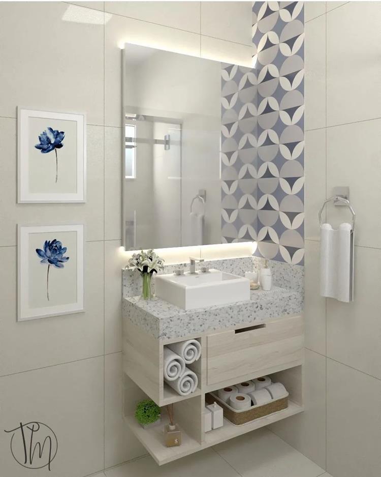 foto de gabinete de um banheiro branco com móveis bege e decoração em parte da parede na cor azul