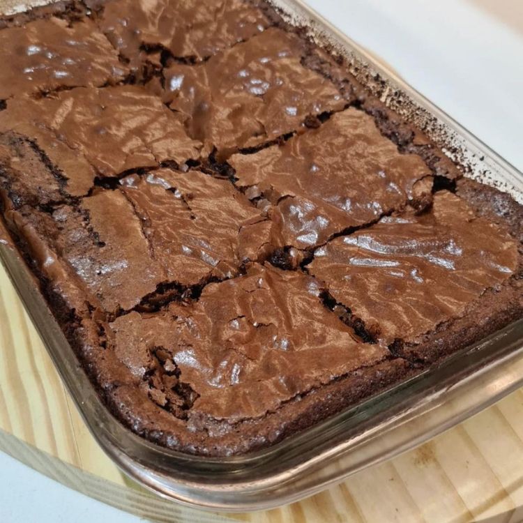 Foto de brownie me forma transparente sobre mesa de madeira