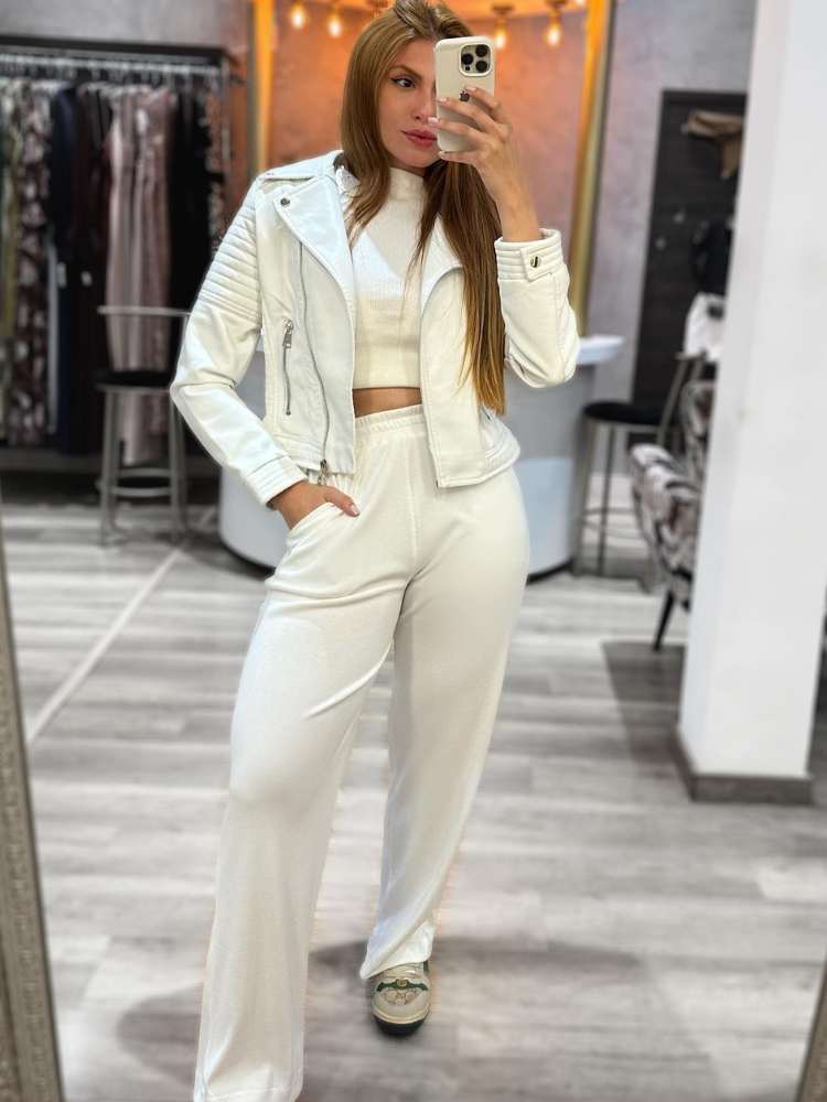 Looks com couro: mulher usando cropped branco, calça de moletom branca + jaqueta de couro branca