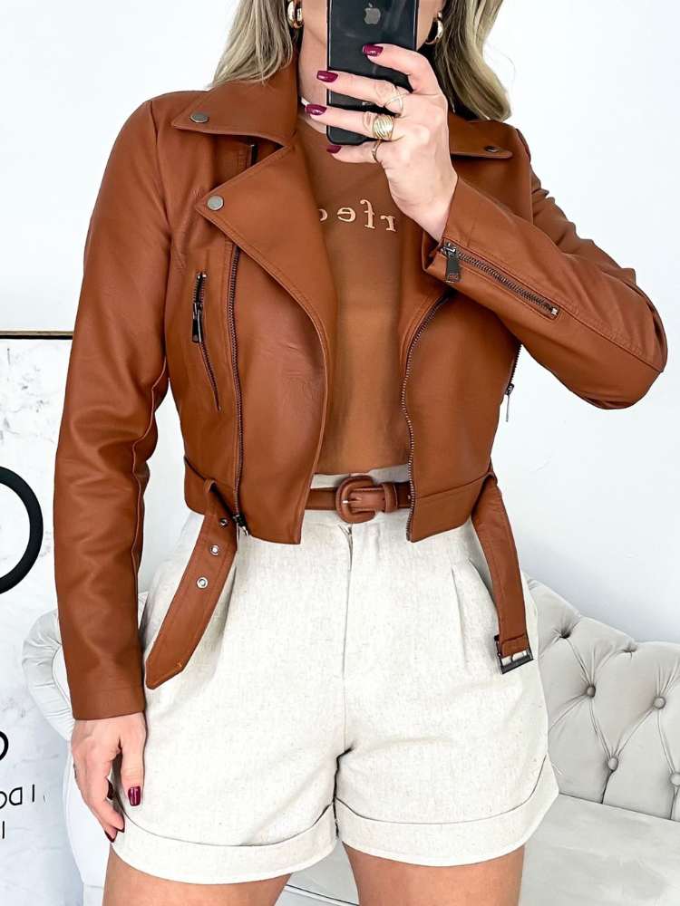 Combinação com courinho: mulher usando camiseta marrom, jaquetaem courino marrom, short off-white, cinto em courino marrom