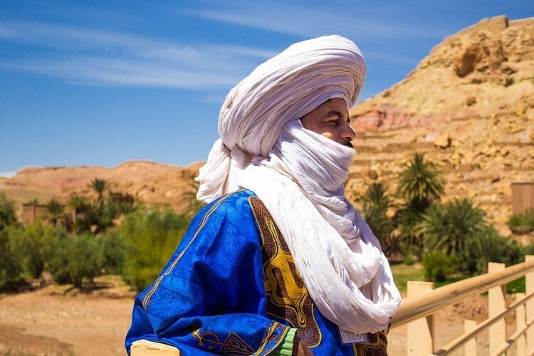 Homem com trajes típicos do Marrocos cobrindo seu cabelo e parte do seu rosto