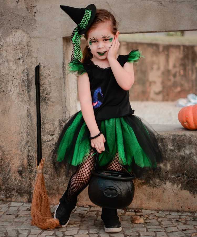 Crianças halloween uma linda garota doce em uma fantasia de bruxa