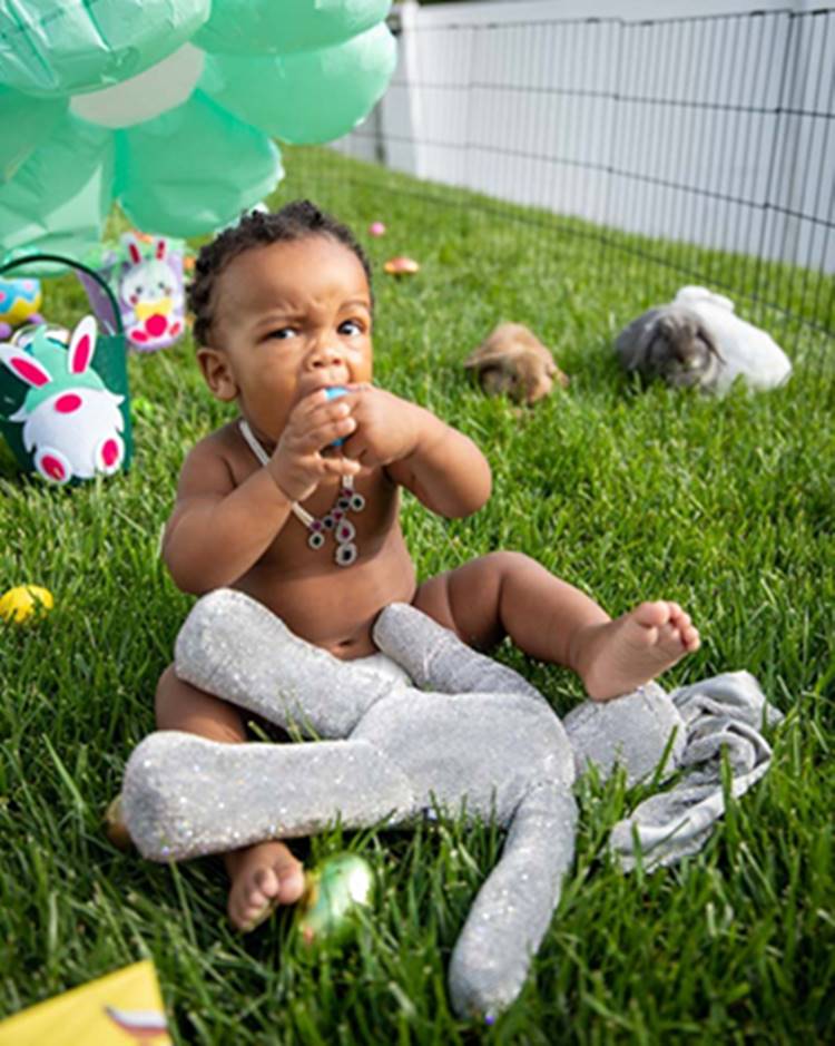 Primeiro filho de Rihanna, sentado em gramado com brinquedos de pelúcia