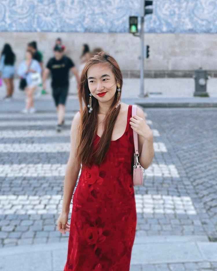 mulher atravessando a rua, veste vestido vermelho comprido