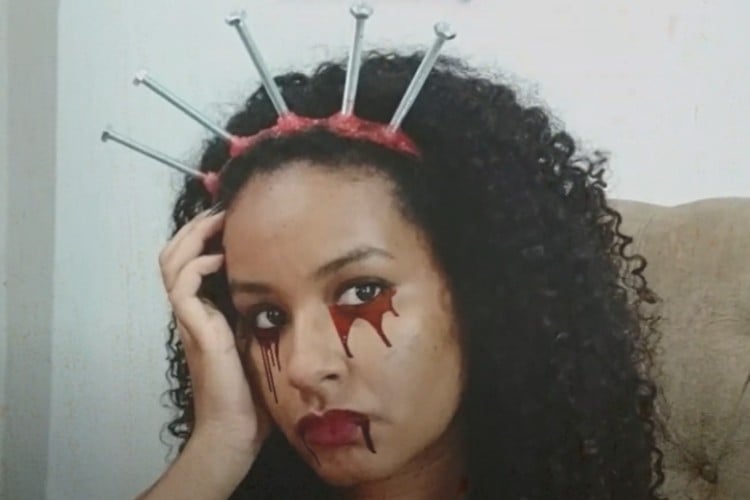 Mulher de pele negra com tiara de parafuso com sangue falso 