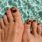 Pés com unhas decoradas na água de piscina