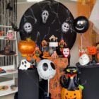 Vitrine de Halloween com máscaras do Pânico, balões de personagens, abóboras, gato preto, mãozinha, chapéu de bruxa e muito mais