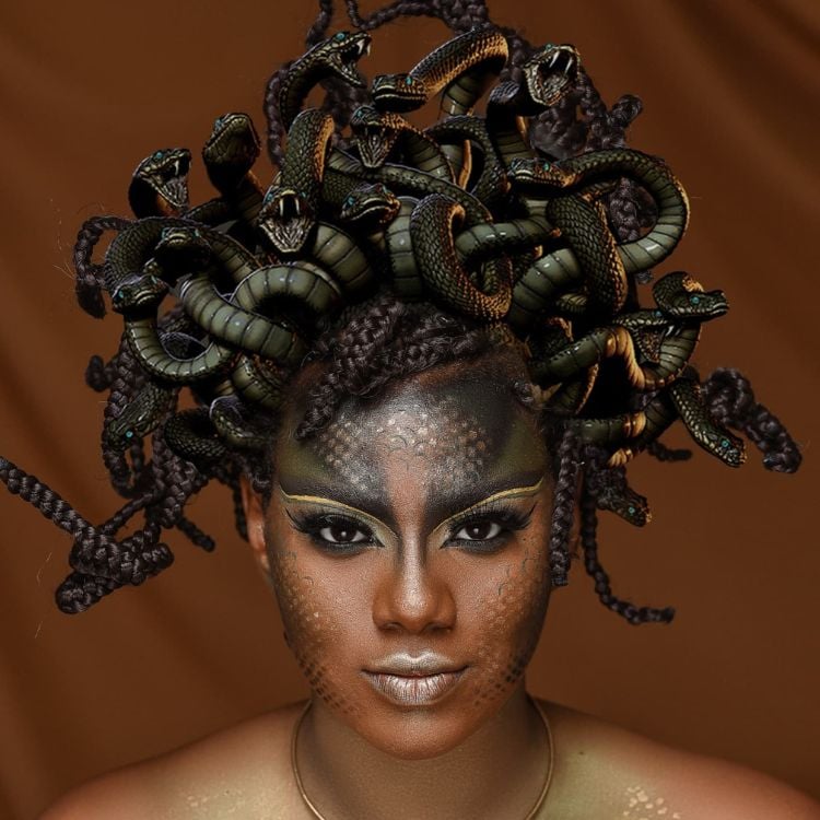 Mulher de pele negra usando maquiagem de Medusa, com sombra cintilante, tons de verde e dourado e efeito de escamadas, além de tiara de cobras