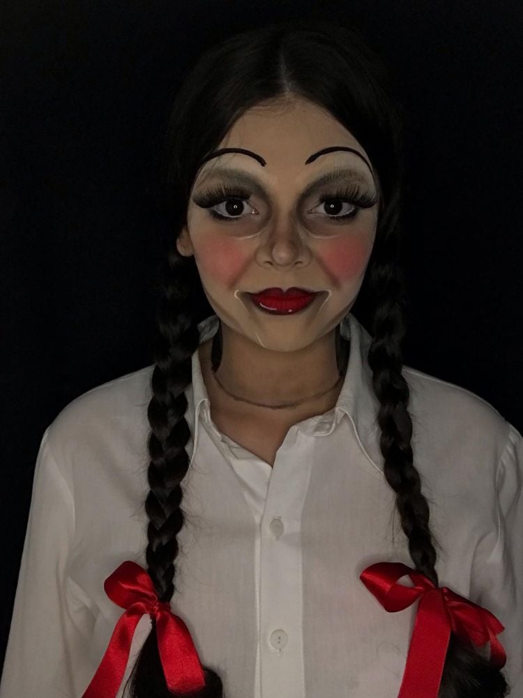 Mulher de pele clara com maquiagem imitando Annabelle