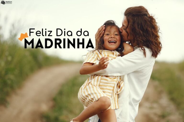 Mulher de pele morena usando vestido branco abraçando e beijando criança também de pele morena em um campo. Ainda, há o dizer "Feliz Dia da Madrinha"