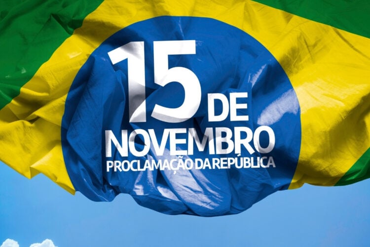 Foto de meia bandeira do Brasil com "15 de novembro Proclamação da República" e céu