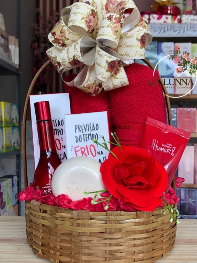 Cesta de palha com produtos de banho e perfumes em vermelho 