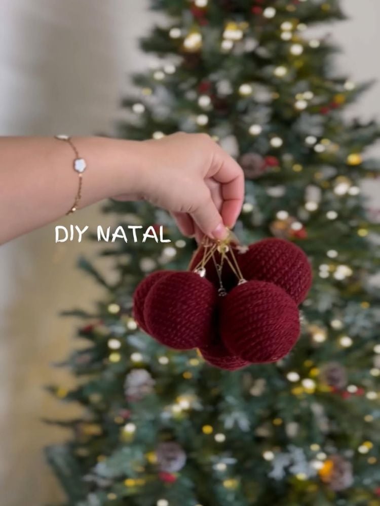 Mulher de pele clara segurando bolas de natal reformadas 