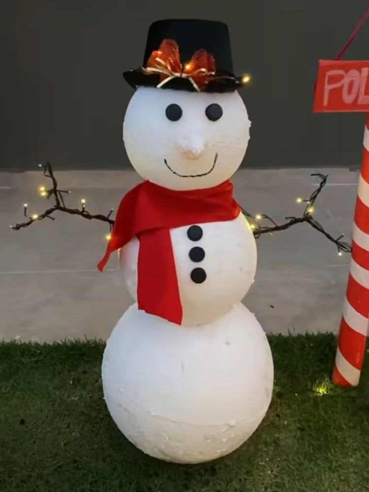 Foto de boneco de neve feito de isopor, galhos, fita e tampa de garrafa