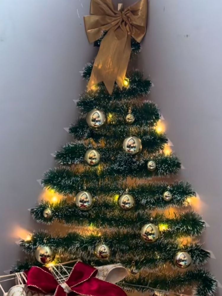 Foto de árvore de Natal feita de festão na parede 