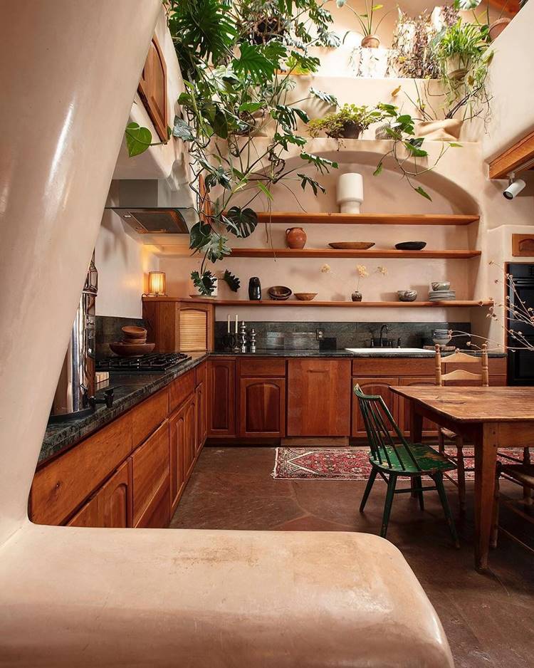 Cozinha rural com prateleiras de madeira e mesa, decorada com plantas