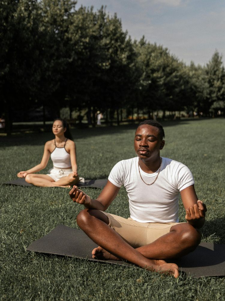 Foto de duas pessoas fazendo exercício de espiritualidade nas empresas na forma de meditação