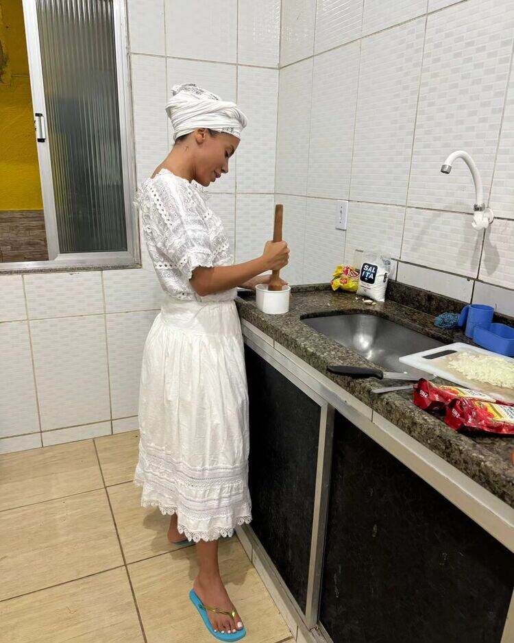 Anitta vestida de branco em uma cozinha de terreiro de candomblé