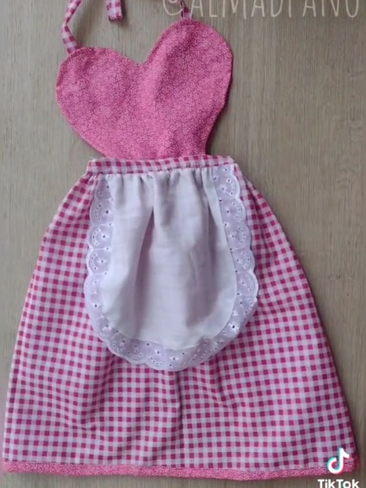 Avental junino pronto, com parte de cima de tecido rosa em formato de coração e saia xadrez branca e rosa