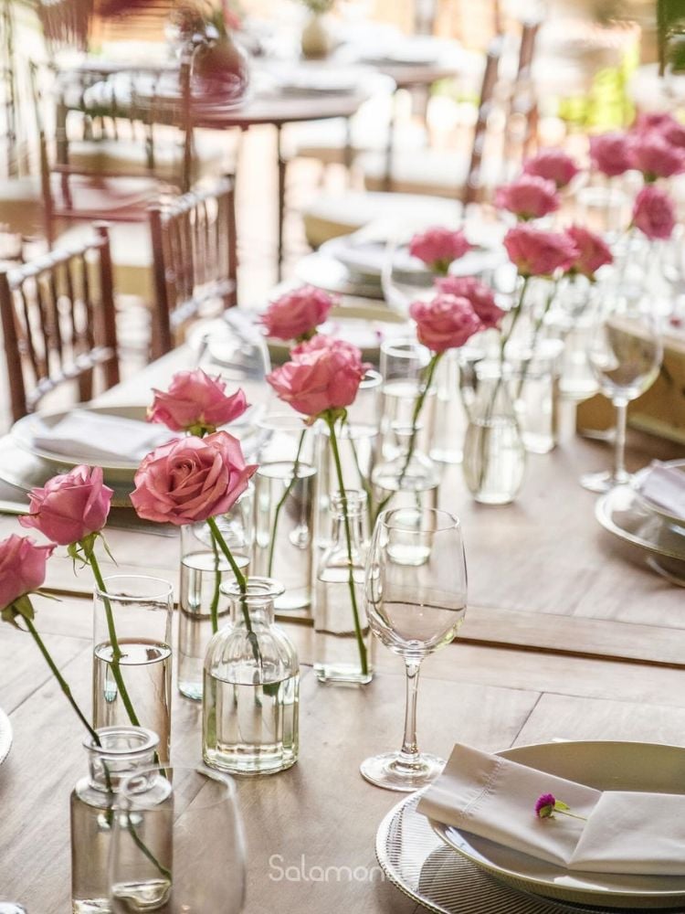 Mesa simples de casamento, com rosas em recipientes de vidro