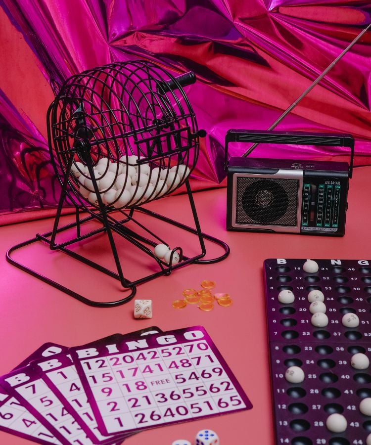 Conjunto de bingo roxo, rosa e preto sob uma mesa rosa