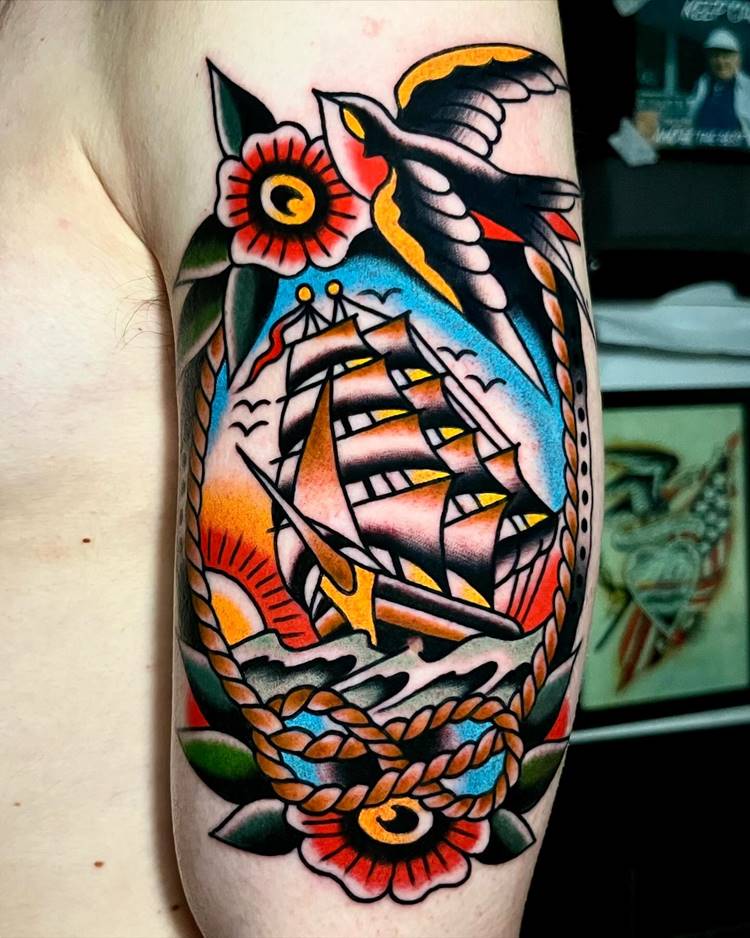 tatuagem de viagem masculina estilo old school de navio com pássaro e flor