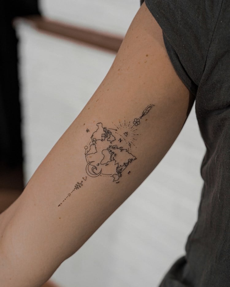 Tatuagem de viagem no braço de mapa-múndi com Norte, Sul, Leste, Oeste e outros desenhos