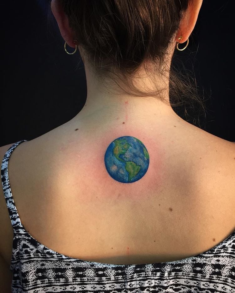 Tatuagem de mundo colorida nas costas de uma mulher
