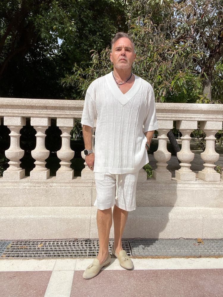 Homem usando conjunto de blusa e short branco de tricô