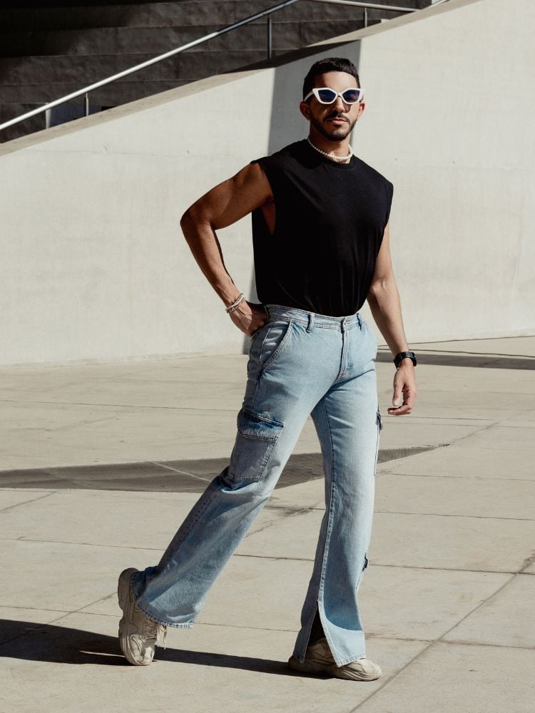 Homem com silhueta masculina triângulo usando regata com ombro largo, calça jeans e tênis branco