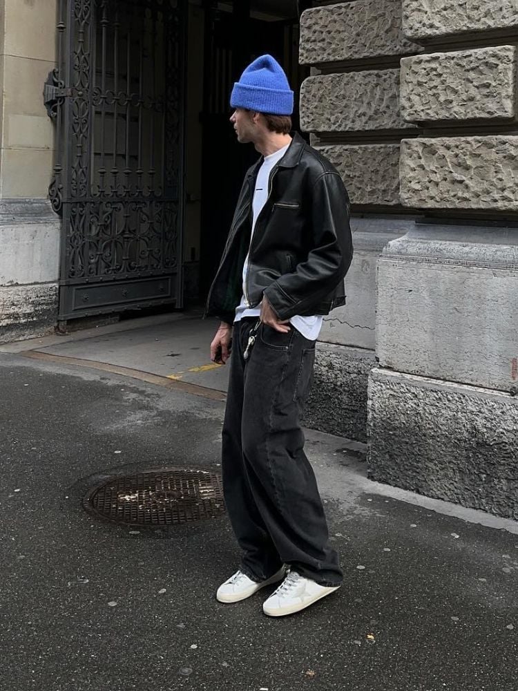 Silhueta masculina usando gorro azul, camiseta branca, jaqueta de couro preta e calça jeans