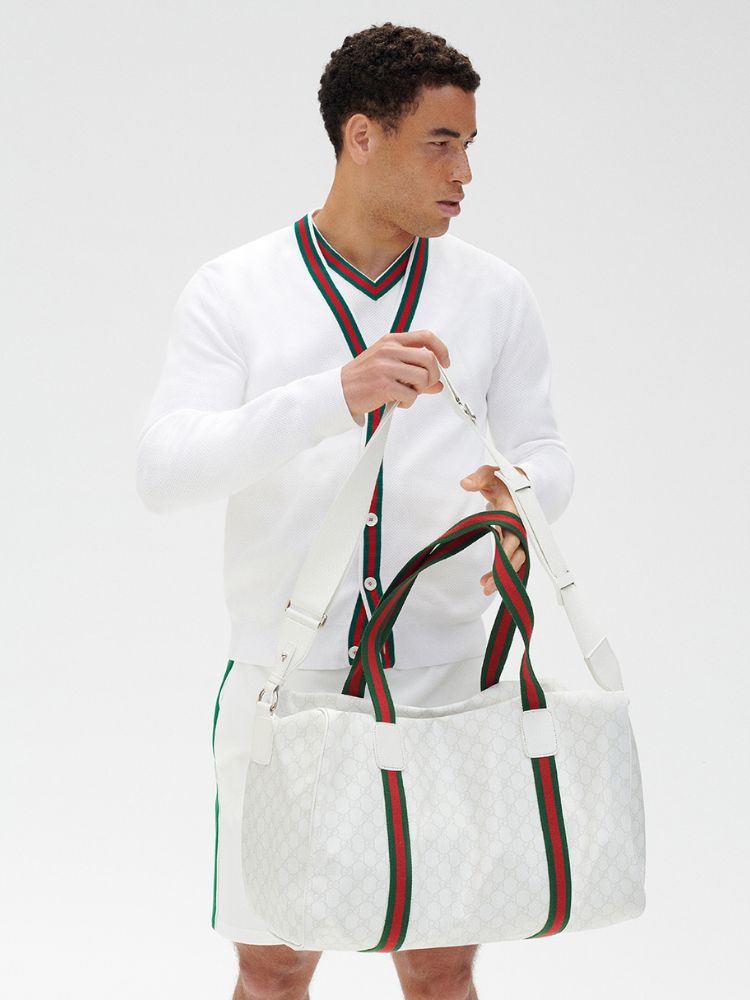 Homem usando look da coleção Gucci Tennis: suéter branco, short e bolsa